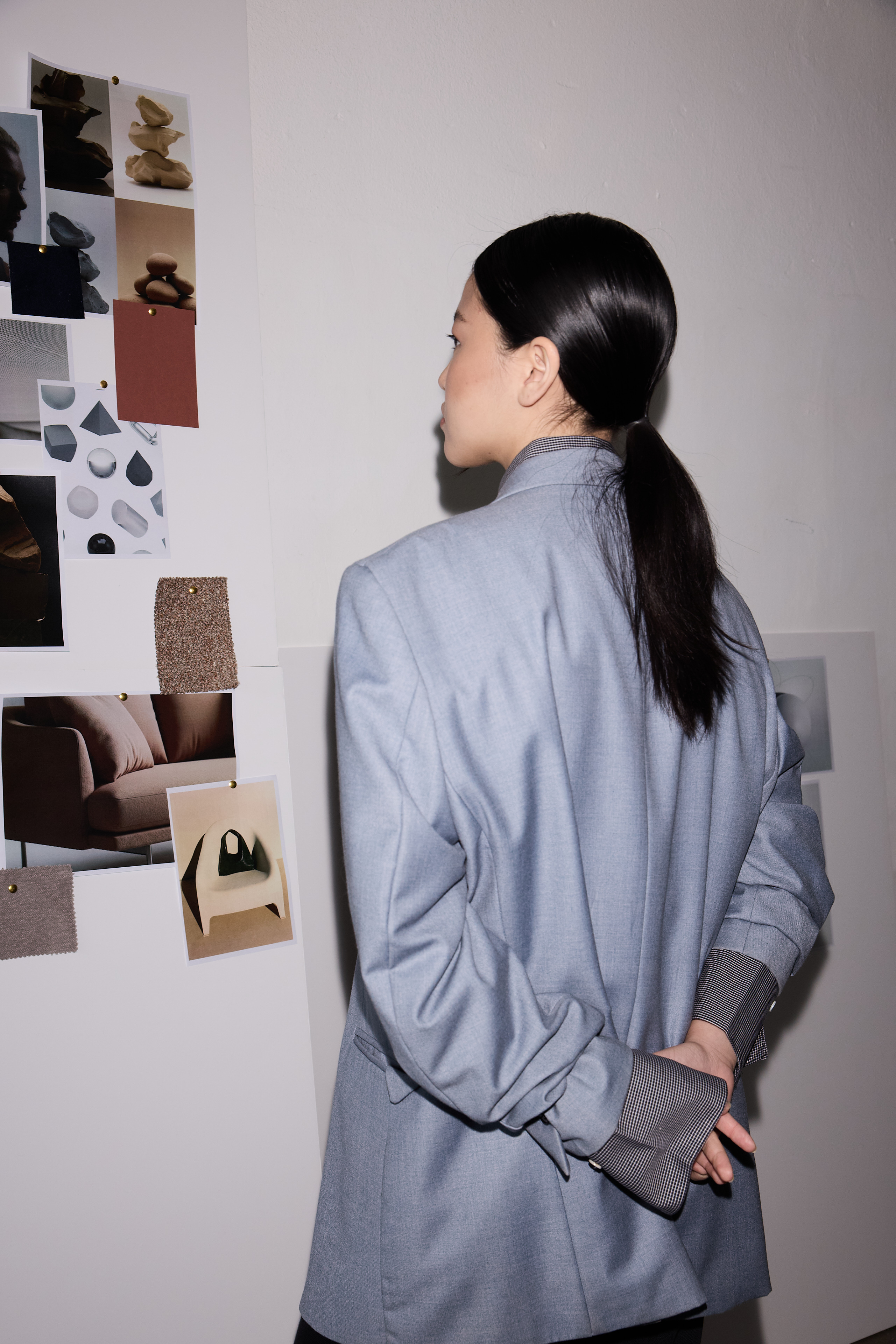 Person studying a creative moodboard pinned to a wall
